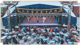 大雪中，观众撑着伞守在戏台前  一台戏，“暖”了寒冬